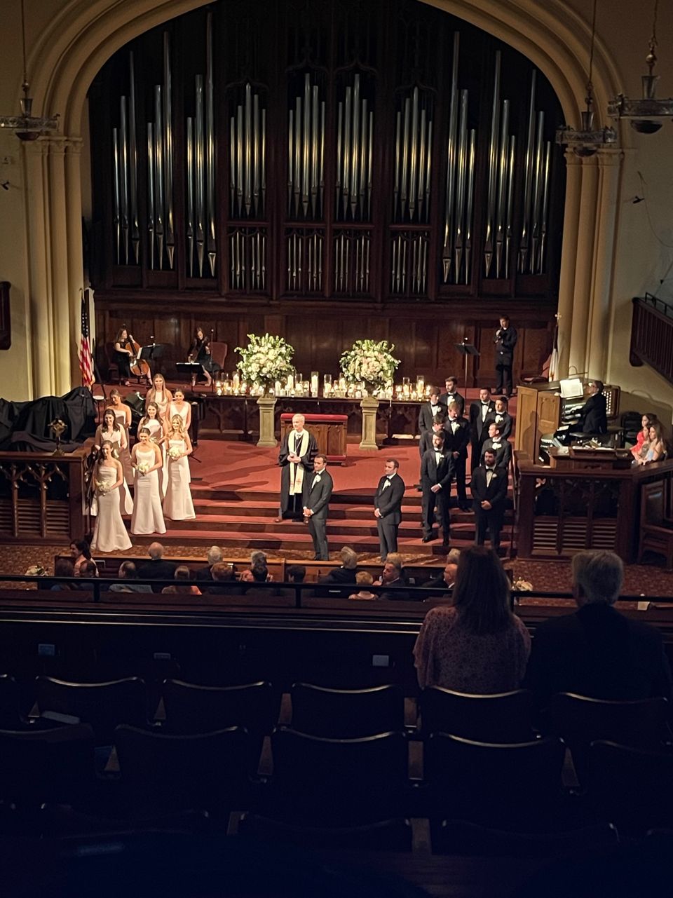 FPCBR Christmas service with deep blue architectural uplighting on the gothic stone arch and organ pipes, performance arrangement, poinsettias.